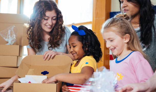 Group of girls opening a Girl Scout experience box. 